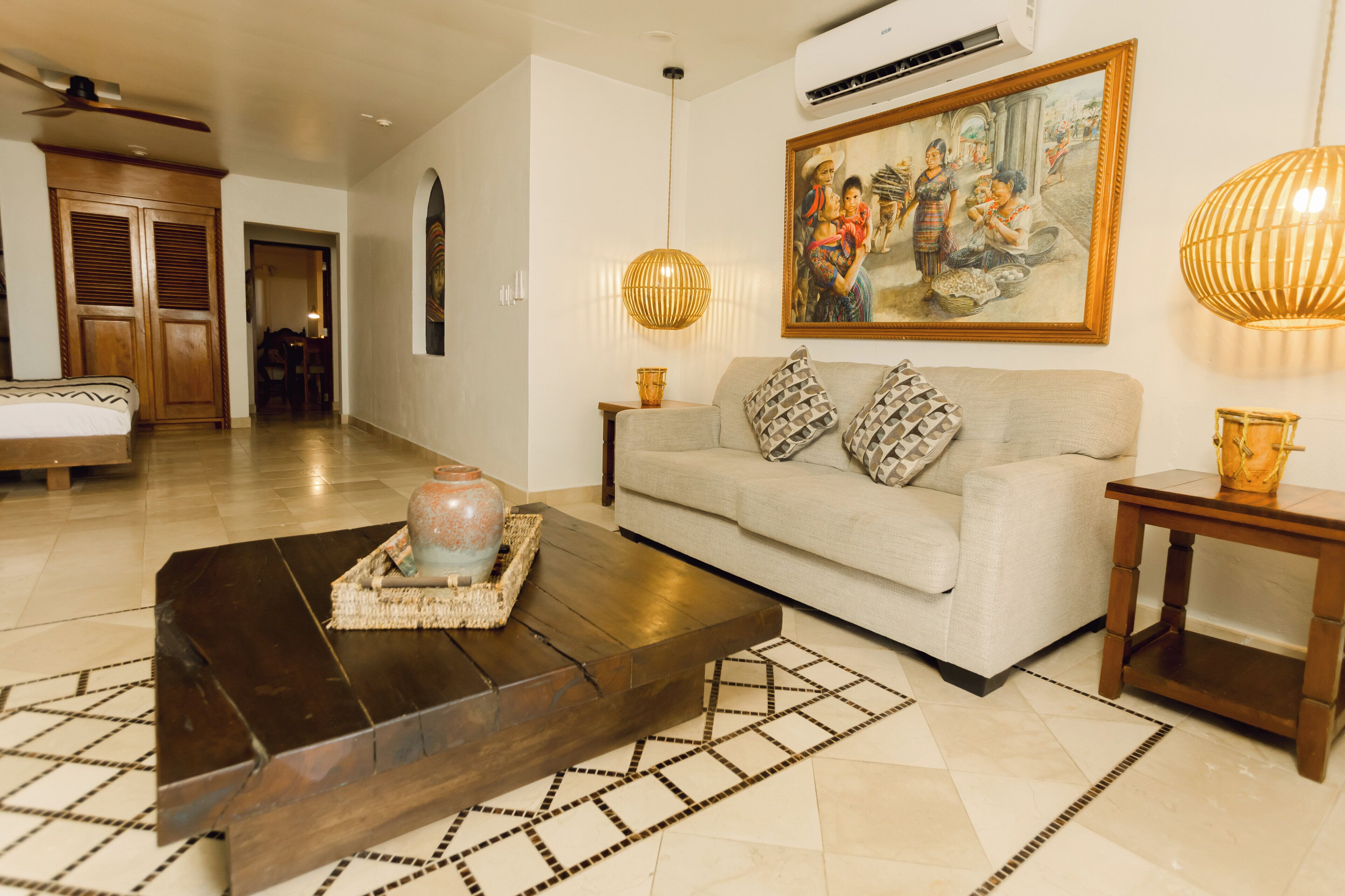A living room with a sofa, a coffee table, a painting, and a lamp.