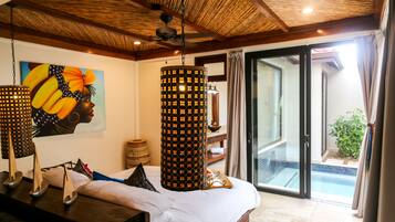 A bedroom with a bed, a ceiling fan, a painting, and a view of a pool through a glass door.