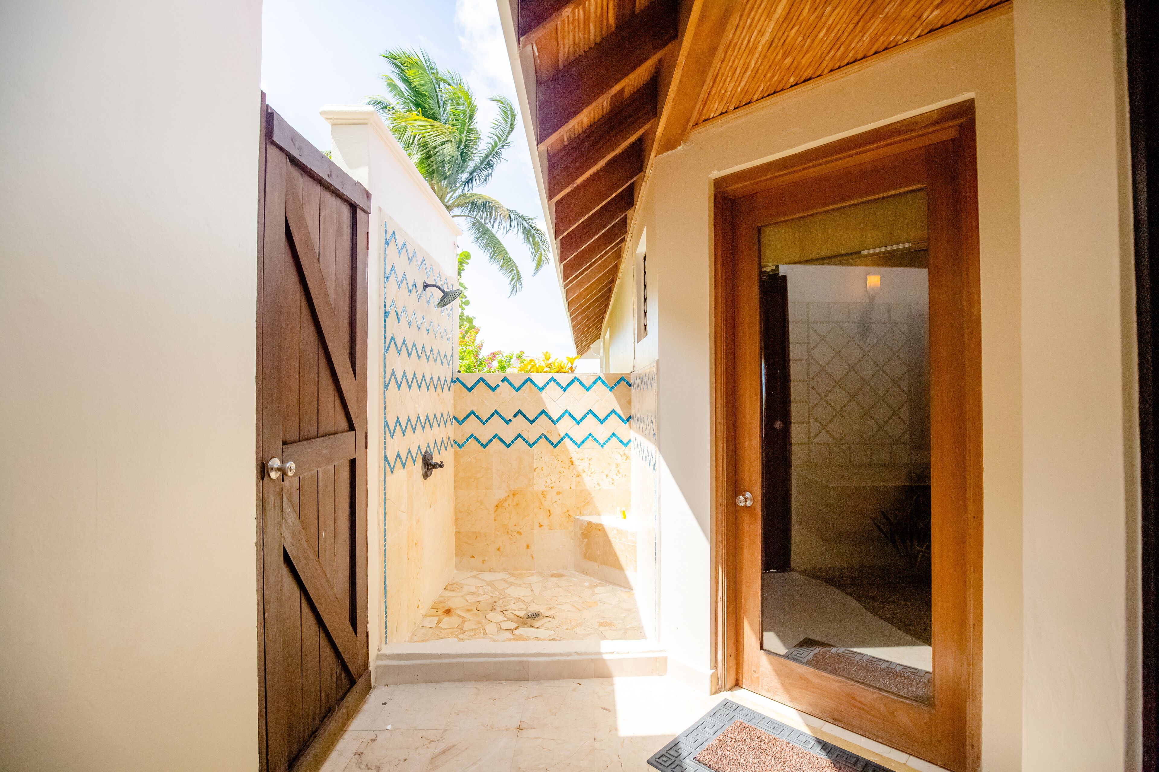 A narrow hallway with a wooden door and a tiled wall.