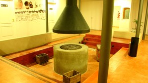 A lobby with a large green conical structure, a wooden bench, and a tiled floor. - Hotel Punta Norte (El Calafate)