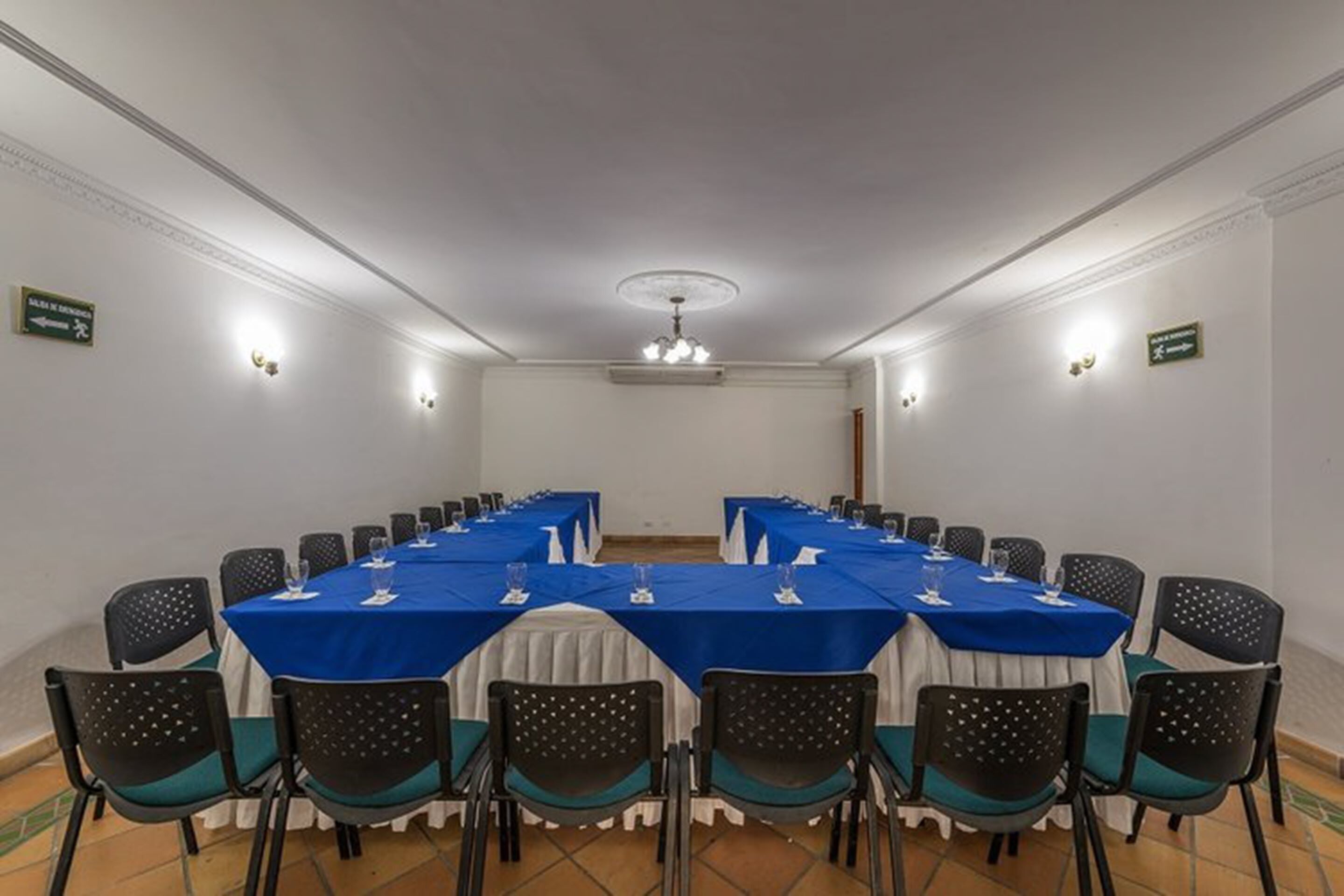 A conference room with a long table, chairs, and a chandelier.