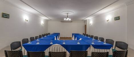 A conference room with a long table, chairs, and a chandelier.