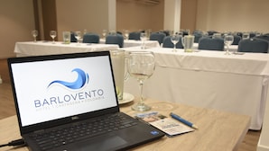 A laptop on a table displaying the Barlovento Hotel logo, with a brochure and a pen beside it.