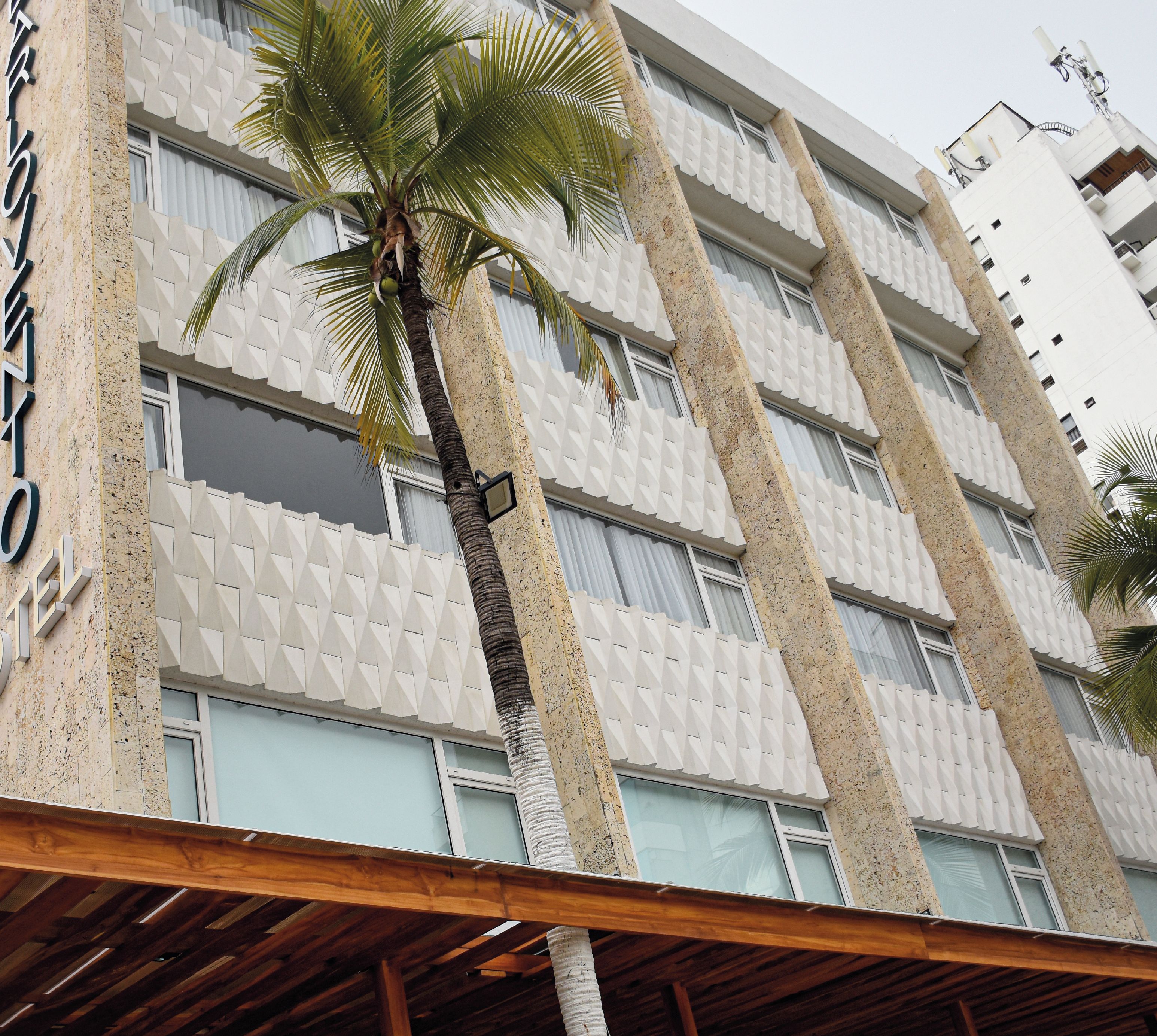 A hotel facade with a modern design, featuring a textured wall and multiple windows.