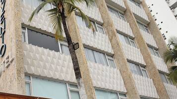 A hotel facade with a modern design, featuring a textured wall and multiple windows.