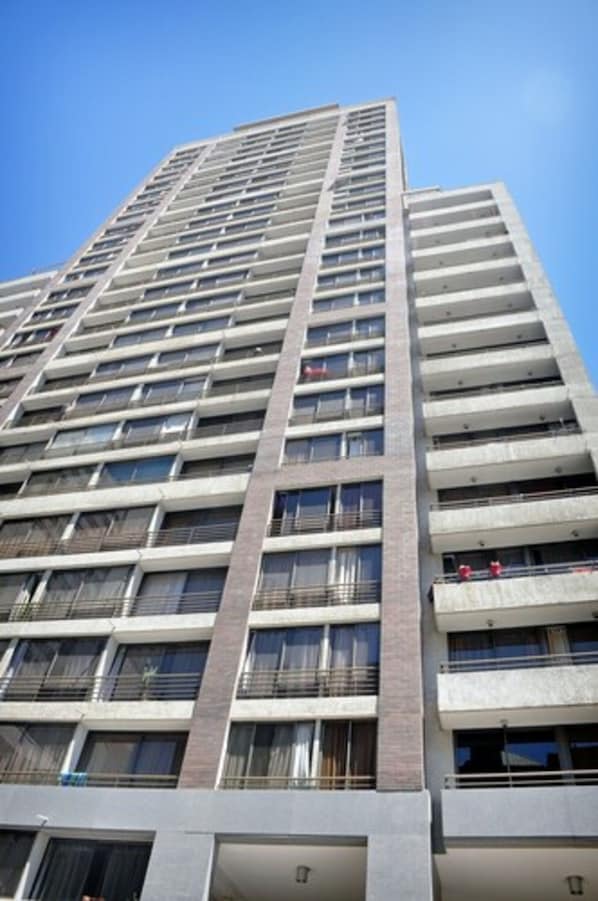 Un edificio de gran altura con varios balcones y un cielo despejado.