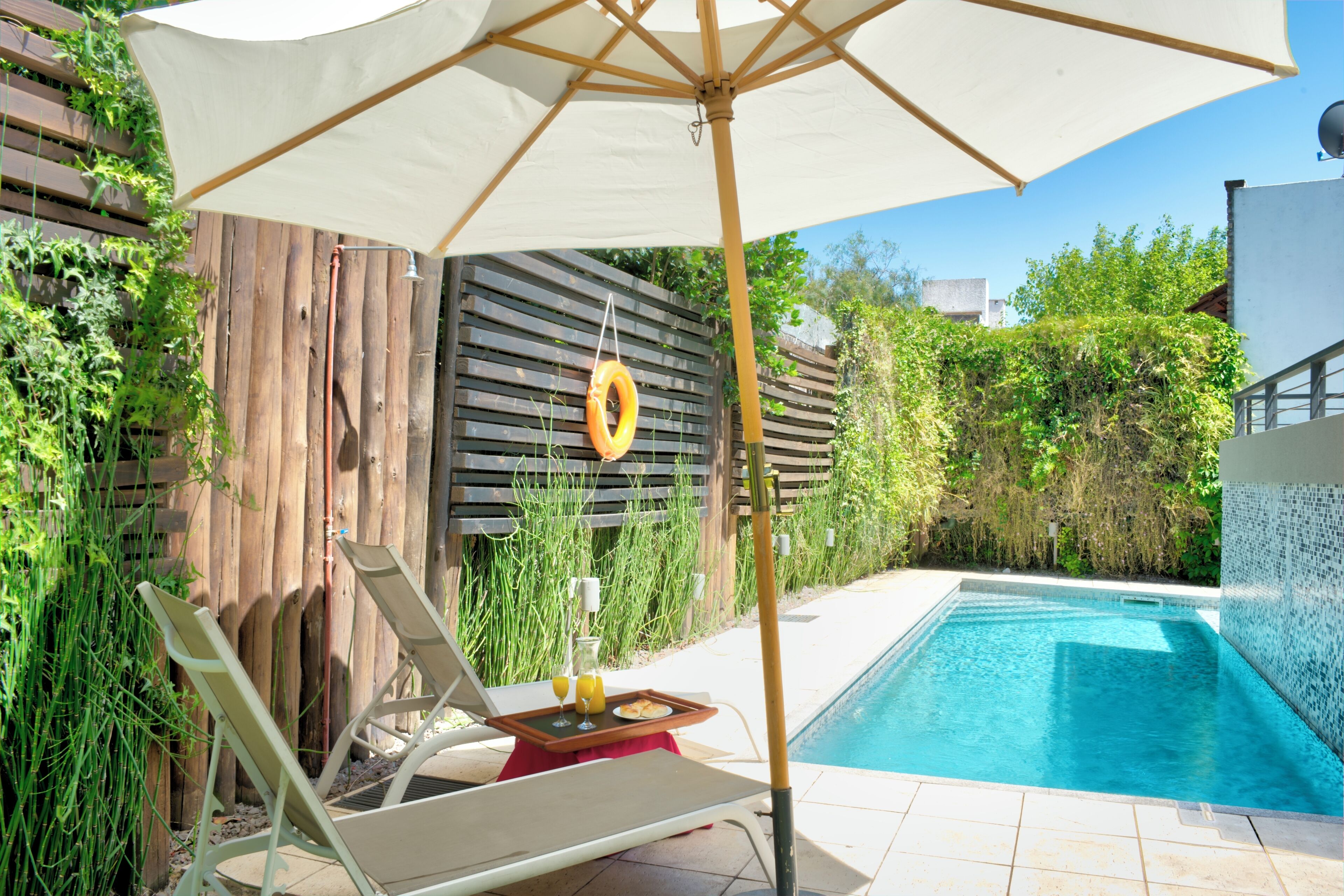 Utomhuspool, parasoller och solstolar