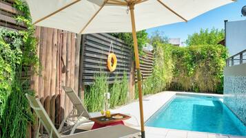 Utomhuspool, parasoller och solstolar