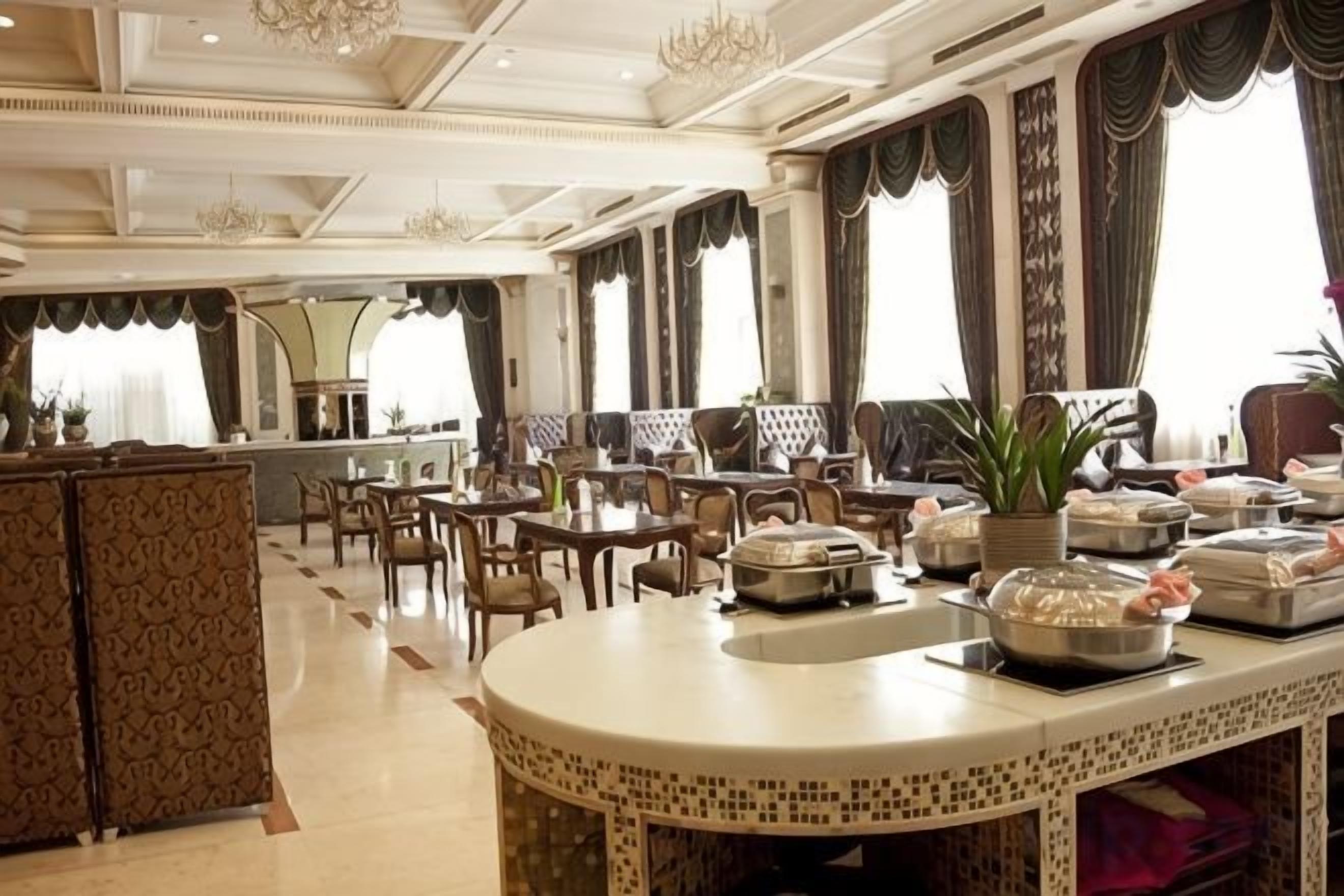 A spacious dining area with a central island, multiple tables, and chairs.