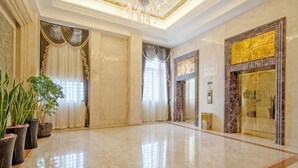 A spacious lobby with a marble floor, large windows with curtains, and a grand chandelier. - Treasure Island Hotel (Wenzhou)