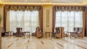 A spacious lobby with a polished marble floor, elegant seating arrangements, and large windows with sheer curtains. - Treasure Island Hotel (Wenzhou)