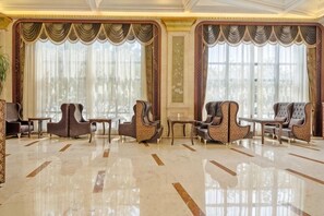 A spacious lobby with a polished marble floor, elegant seating arrangements, and large windows with sheer curtains. - Treasure Island Hotel (Wenzhou)