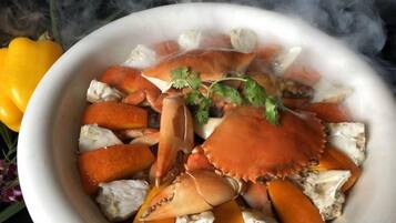 A bowl of crab with a garnish, surrounded by smoke.