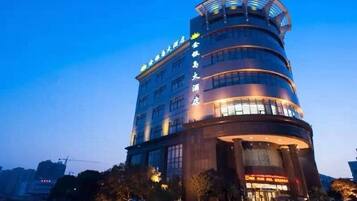 A multi-story hotel with a curved facade, large windows, and a prominent entrance.