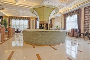 A lobby with a central round bar, a chandelier, and a large window with curtains. - Treasure Island Hotel (Wenzhou)