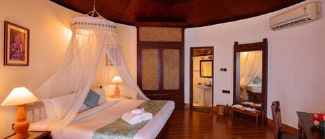 Un dormitorio con cama, mesita de noche, lámpara y ventilador de techo.