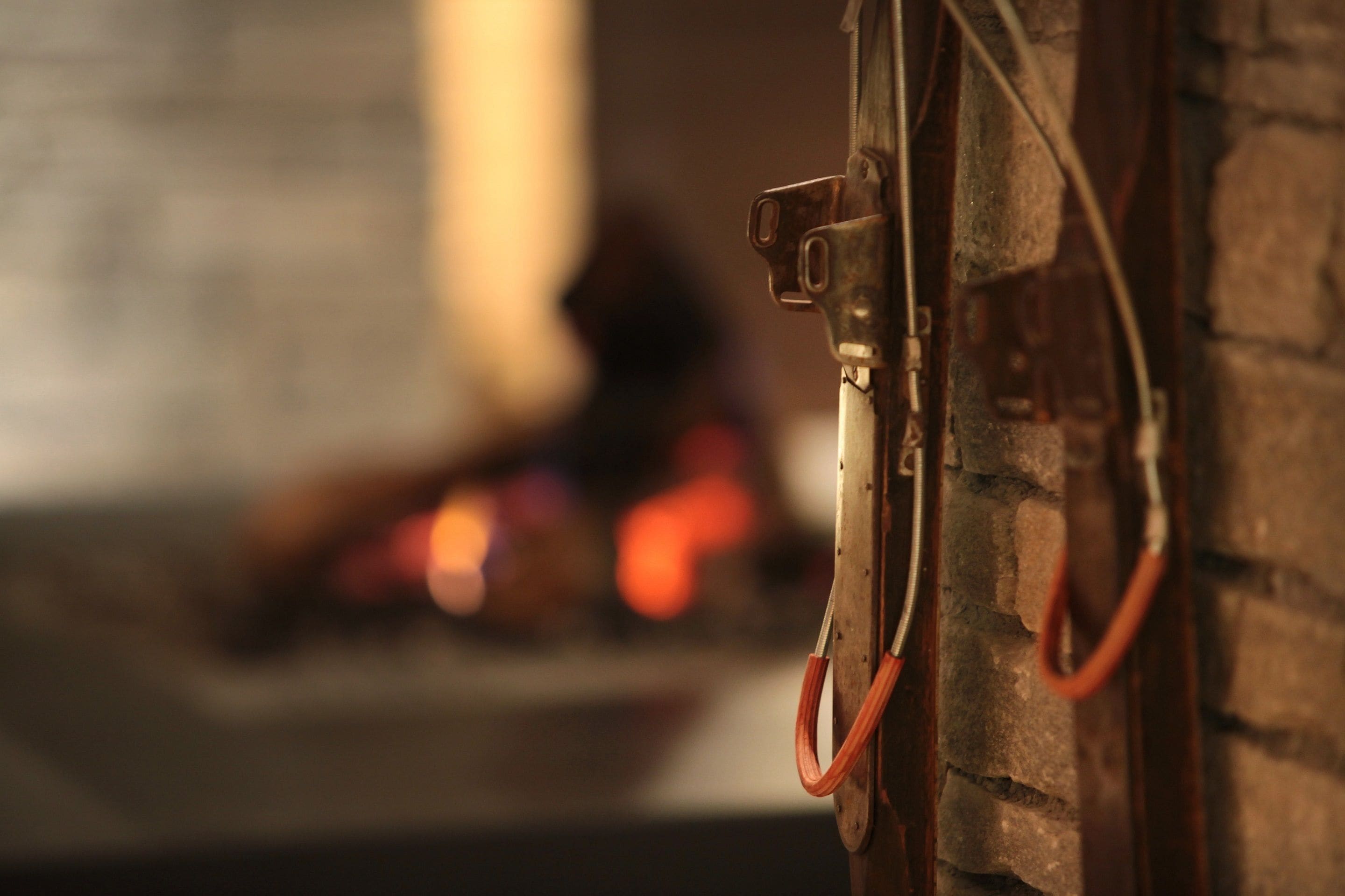 A close-up of a fireplace with a metal grate and a red hose attached to it.