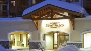 A hotel entrance with a snow-covered roof and a sign reading "Mont Vallon Spa Resort". - Residence Le Chalet du Mont Vallon (Les Belleville)