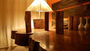 Une table en bois, une lampe, une sculpture en pierre et des vases.