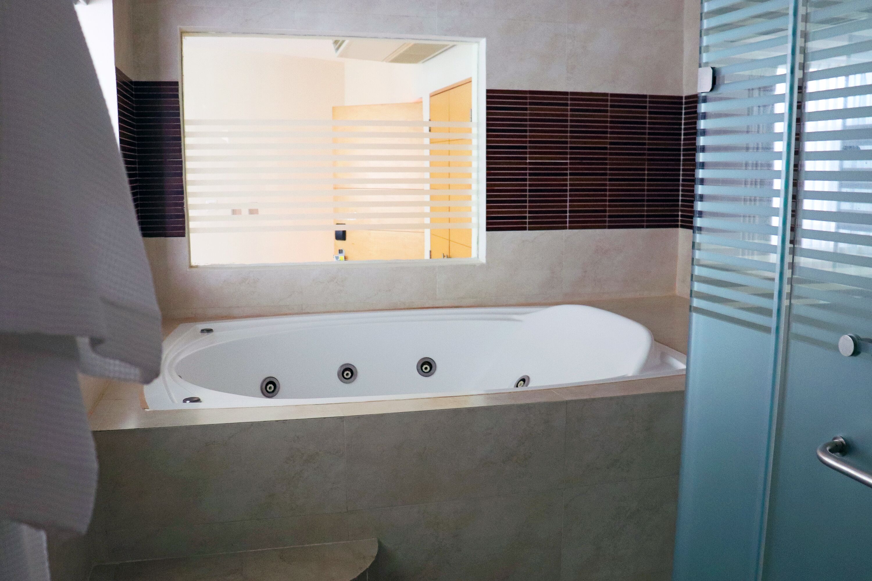 Un baño moderno con una bañera grande, un espejo y un box de ducha de vidrio.