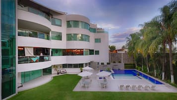 Een buitenzwembad, parasols voor strand/zwembad