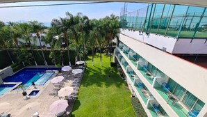A hotel with a swimming pool, outdoor seating, and a view of the surrounding greenery. - Hotel Río 1300 (Cuernavaca)