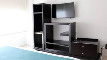 Una habitación moderna con una unidad de entretenimiento negra, un televisor de pantalla plana y una pared de acento color verde azulado.