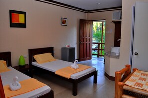 Habitación de hotel con dos camas, una mesa de madera, una silla, un florero verde y un cuadro en la pared.