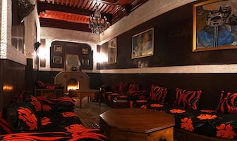 Una habitación acogedora con chimenea, sofás con estampado y un cuadro en la pared.