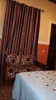 Una stanza con un letto, un divano e una tenda.