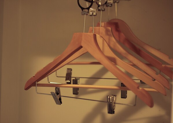 A wooden hanger rack with multiple hangers. - Casablanca Suites Near Airport (Legazpi)