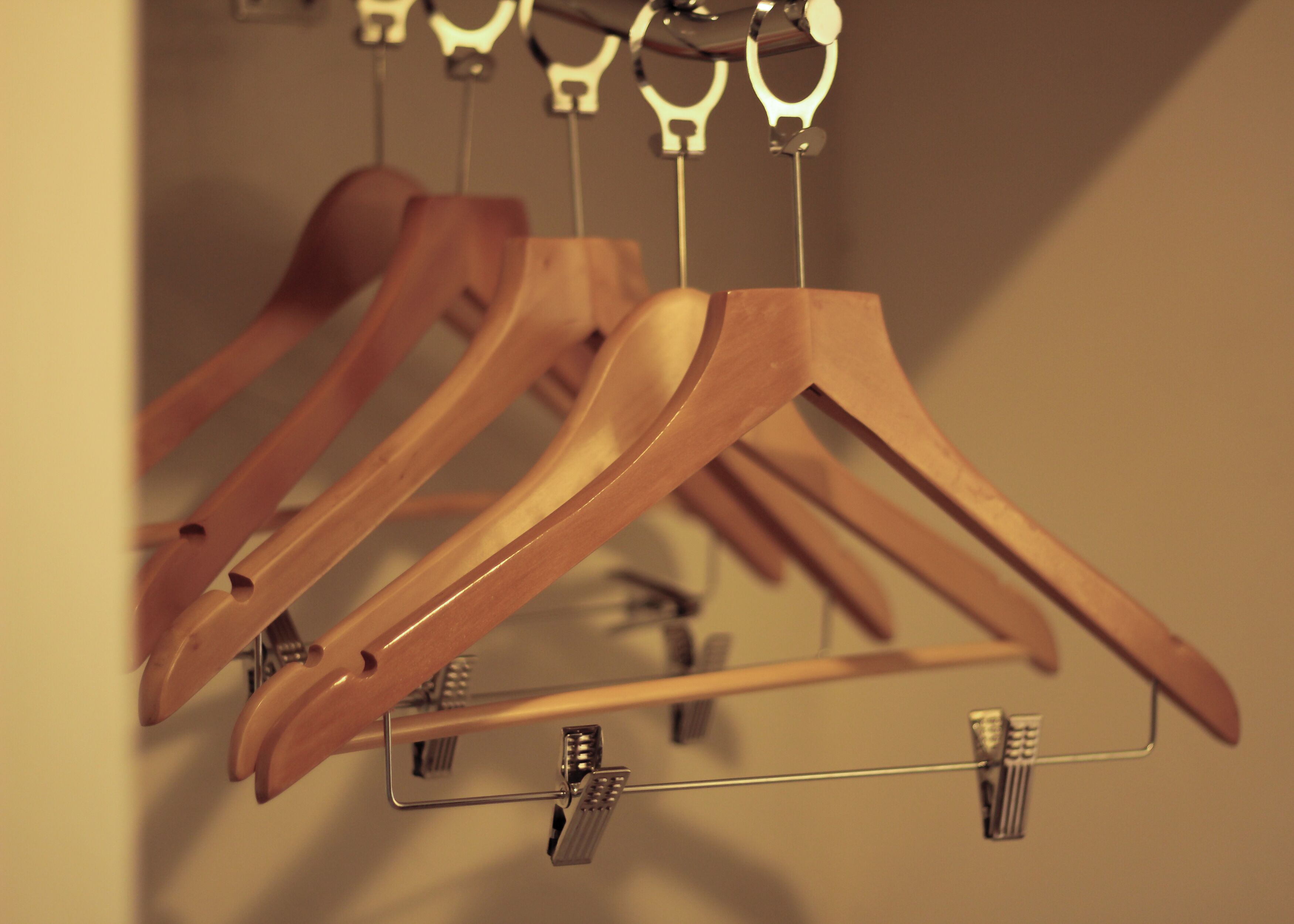 Wooden hangers hanging on a metal rack.