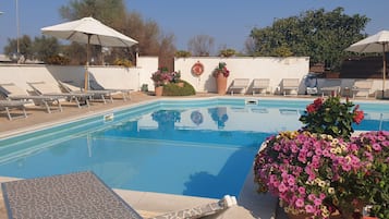 Een seizoensgebonden buitenzwembad, parasols voor strand/zwembad