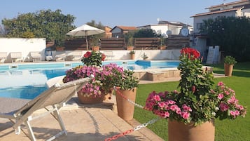 Een seizoensgebonden buitenzwembad, parasols voor strand/zwembad