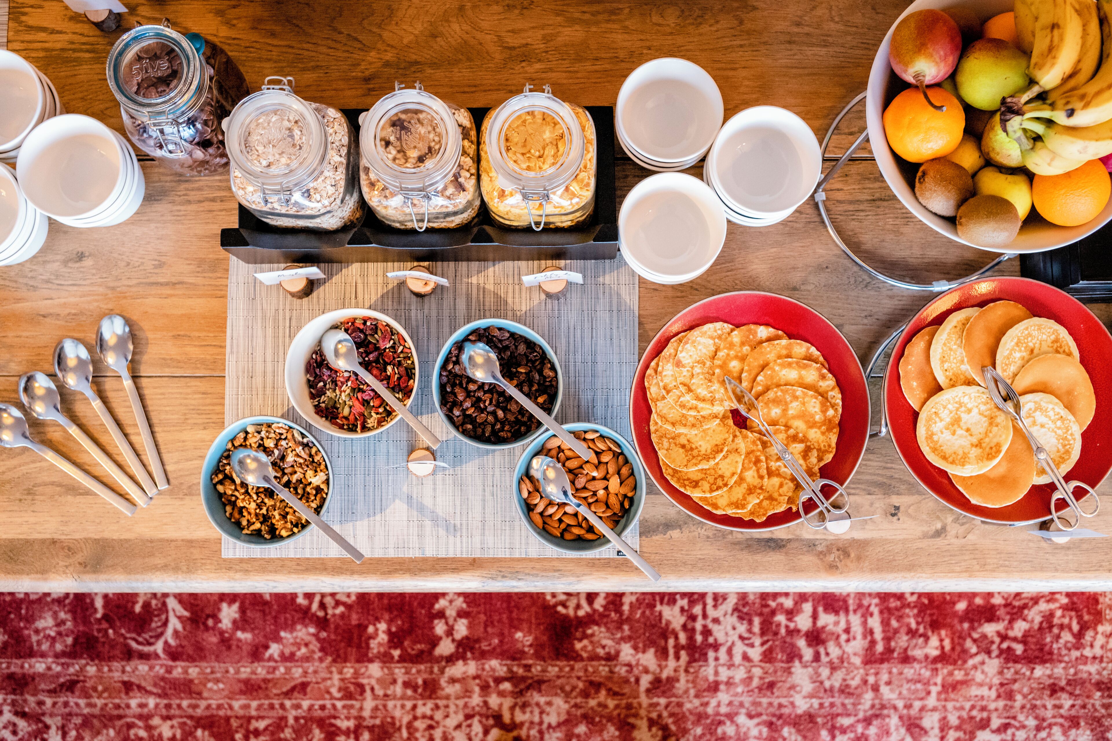 A breakfast buffet with various food items and utensils.