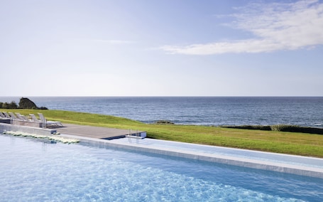 Una piscina al aire libre de temporada, sombrillas