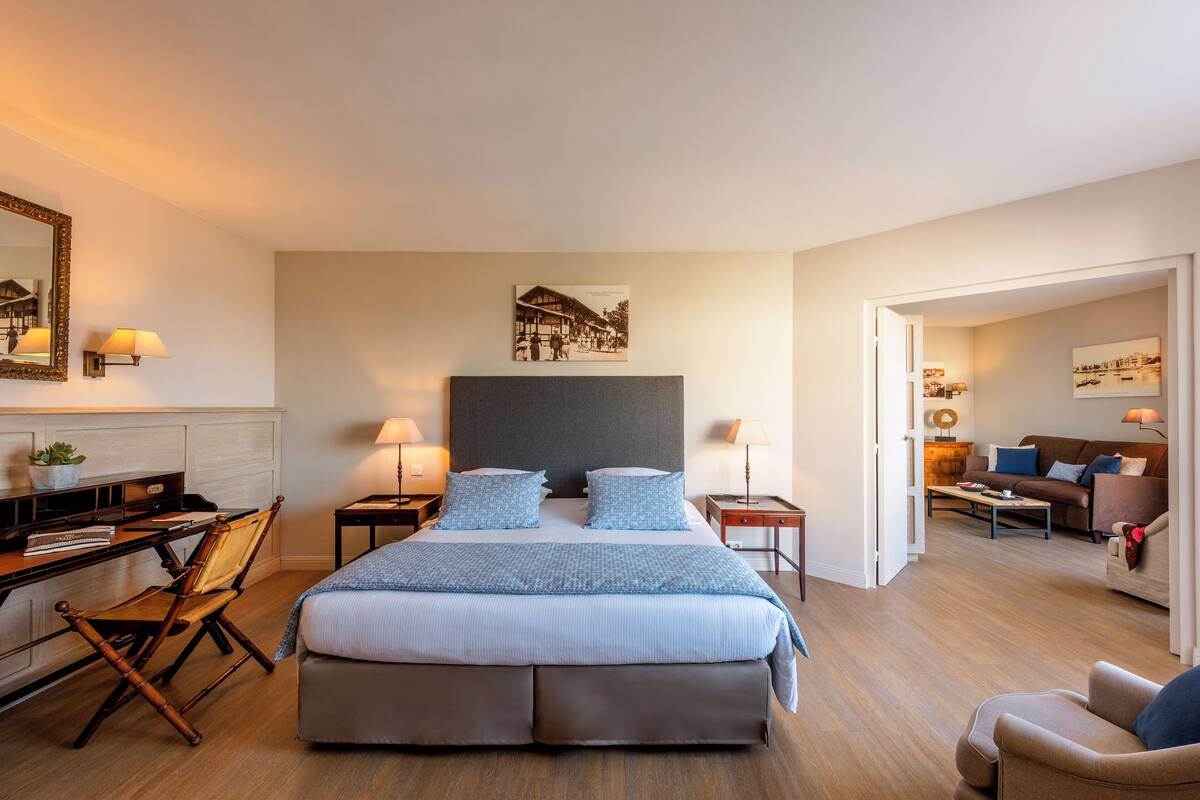 Una habitación de hotel moderna con una cama grande, un escritorio y una zona de estar.