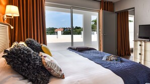 Una habitación de hotel con una cama grande, televisión y vistas al exterior.