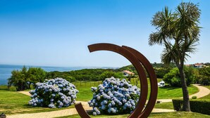 Una escultura en un jardín con vista al mar.