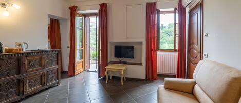 A living room with a sofa, a television, a wooden cabinet, and a small table.