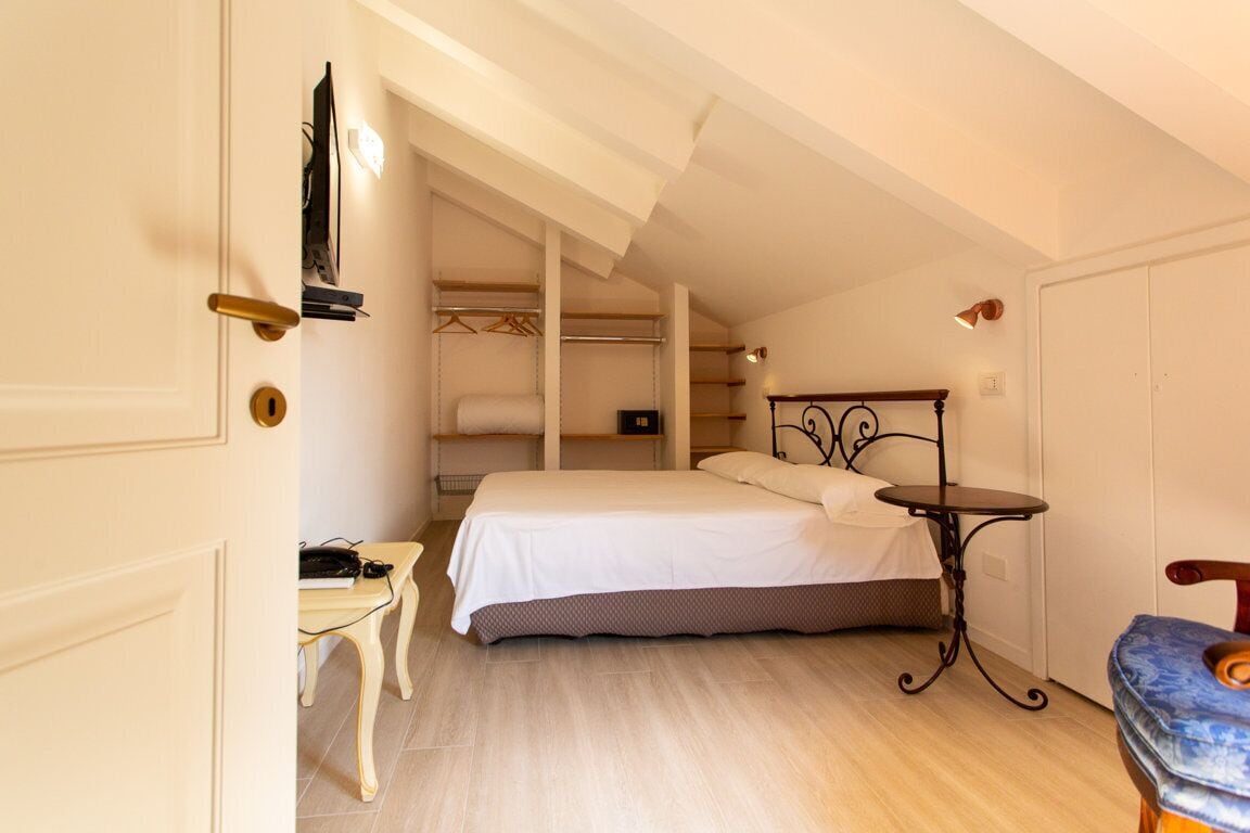 Ein Schlafzimmer mit Bett, Nachttisch und Kleiderschrank.