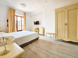 A bedroom with a bed, a desk, a chair, a wardrobe, and a television. - Relais Il Casale (Tovo San Giacomo)