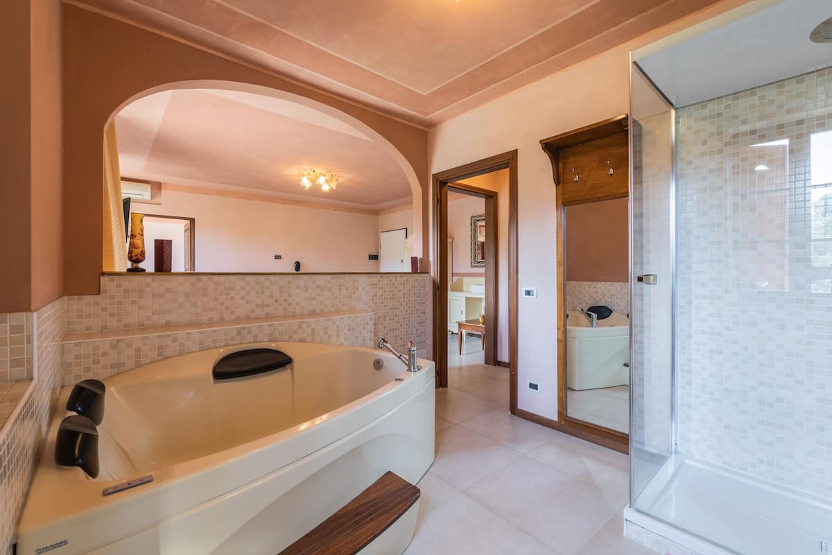 A spacious bathroom with a large bathtub, a glass shower enclosure, and a vanity with a sink.