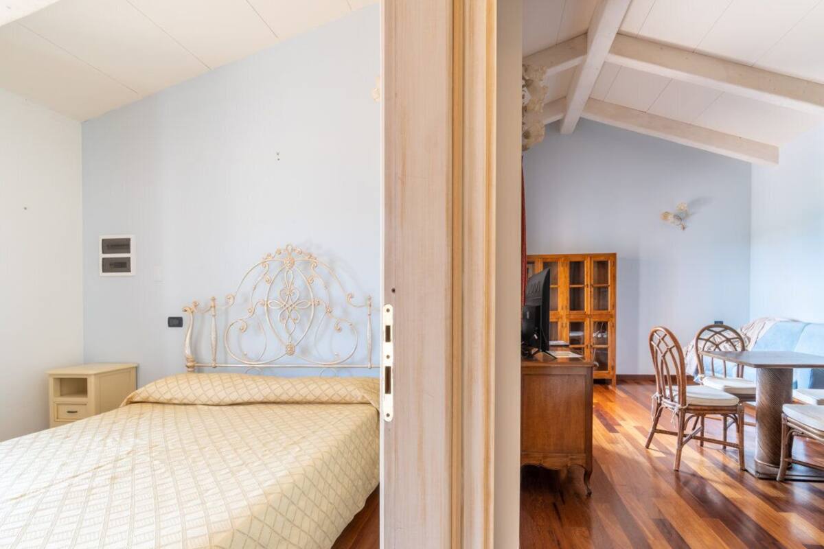 A bedroom with a bed, bedside table, and a wooden cabinet.