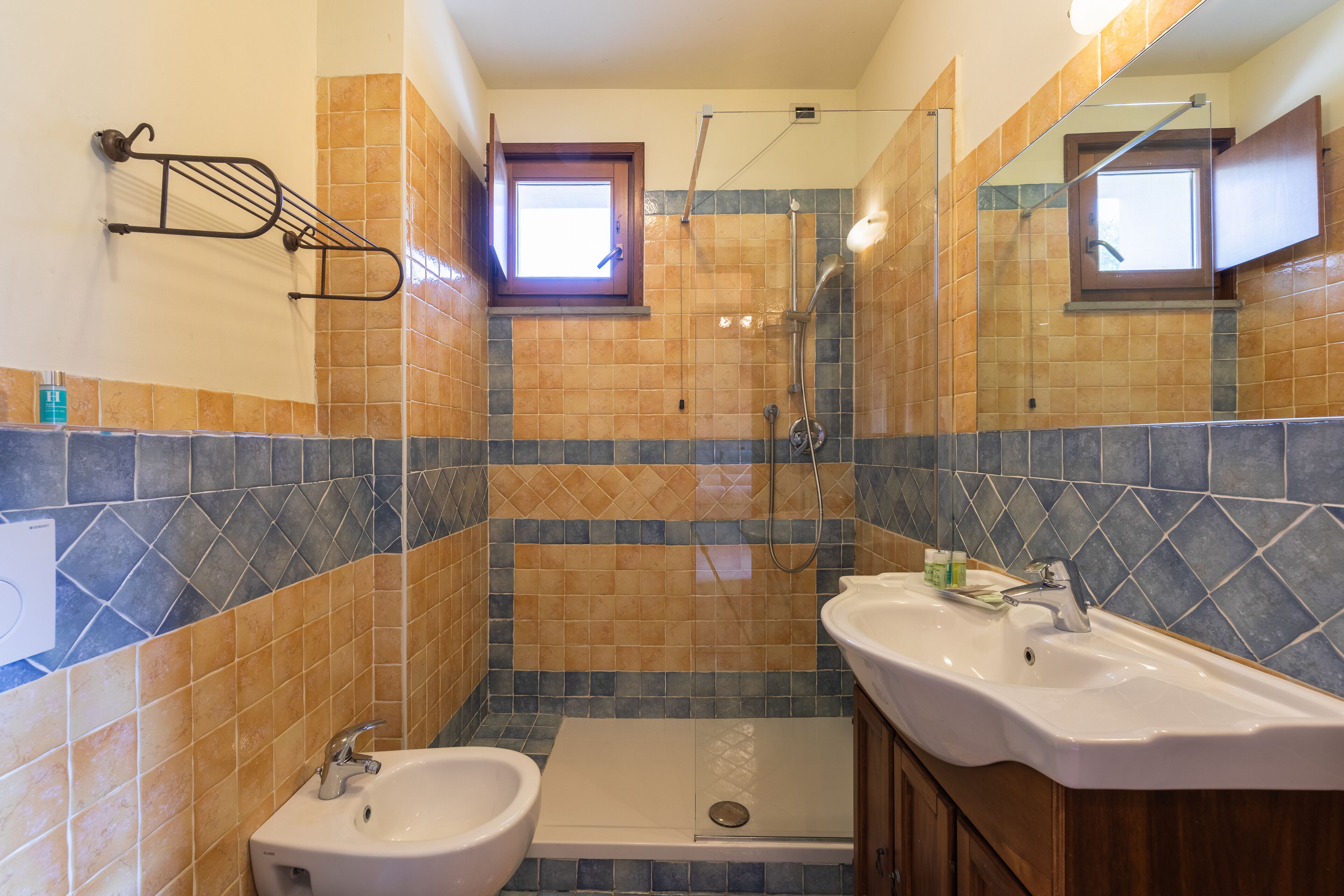 Un baño con dos lavamanos, ducha y ventana.