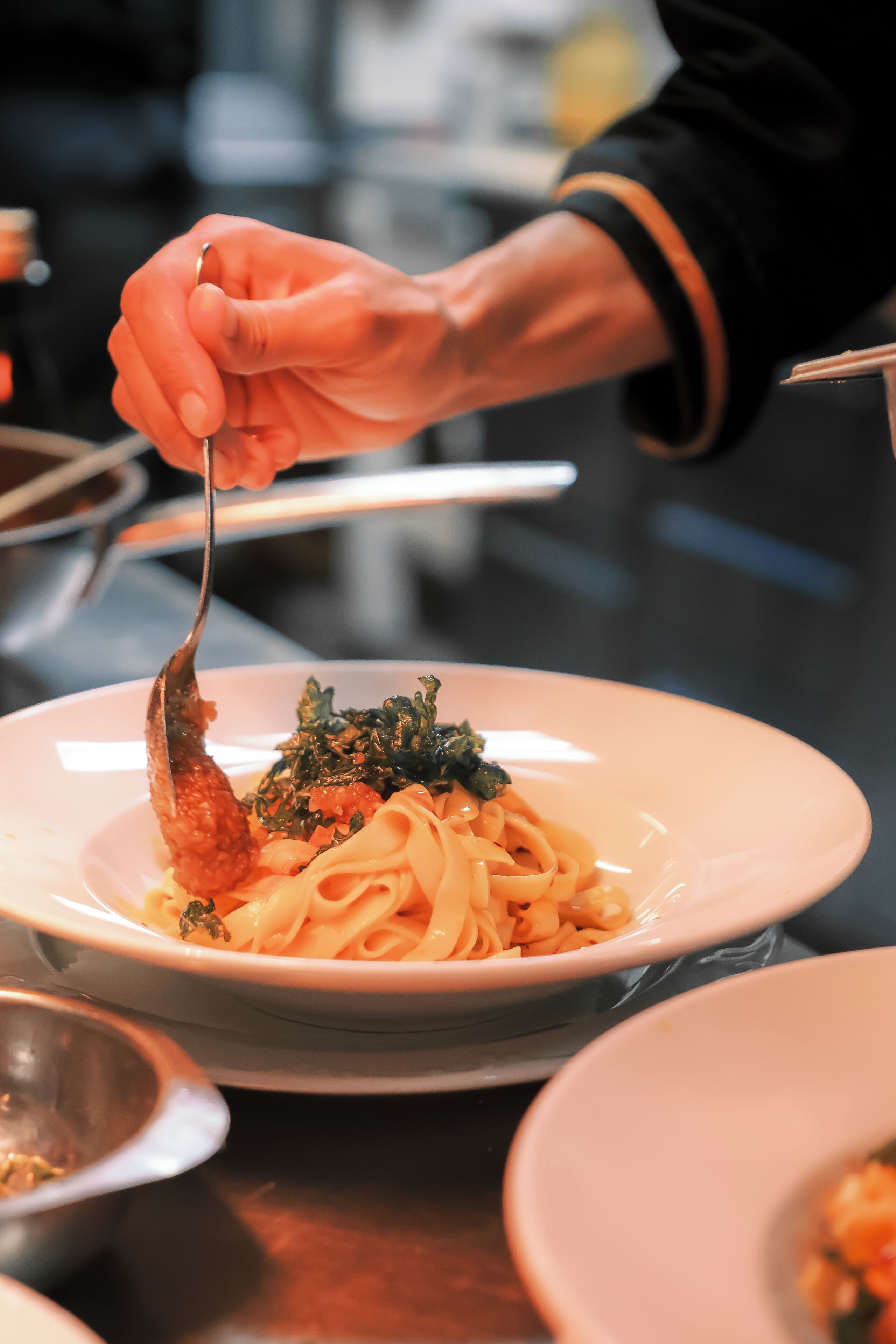 A person serving pasta with a fork.