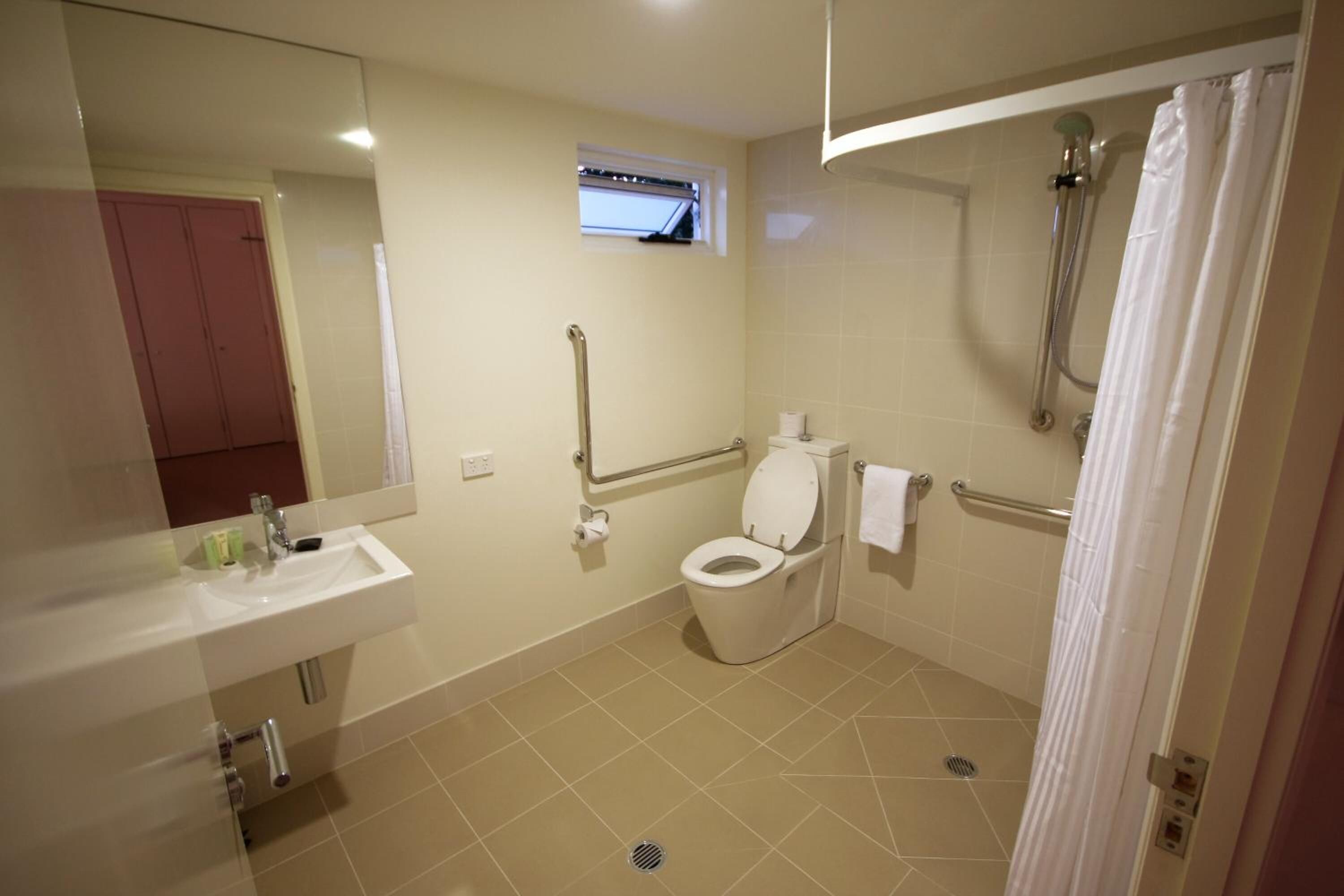 A bathroom with a toilet, sink, and shower.