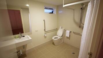 A bathroom with a toilet, sink, and shower.