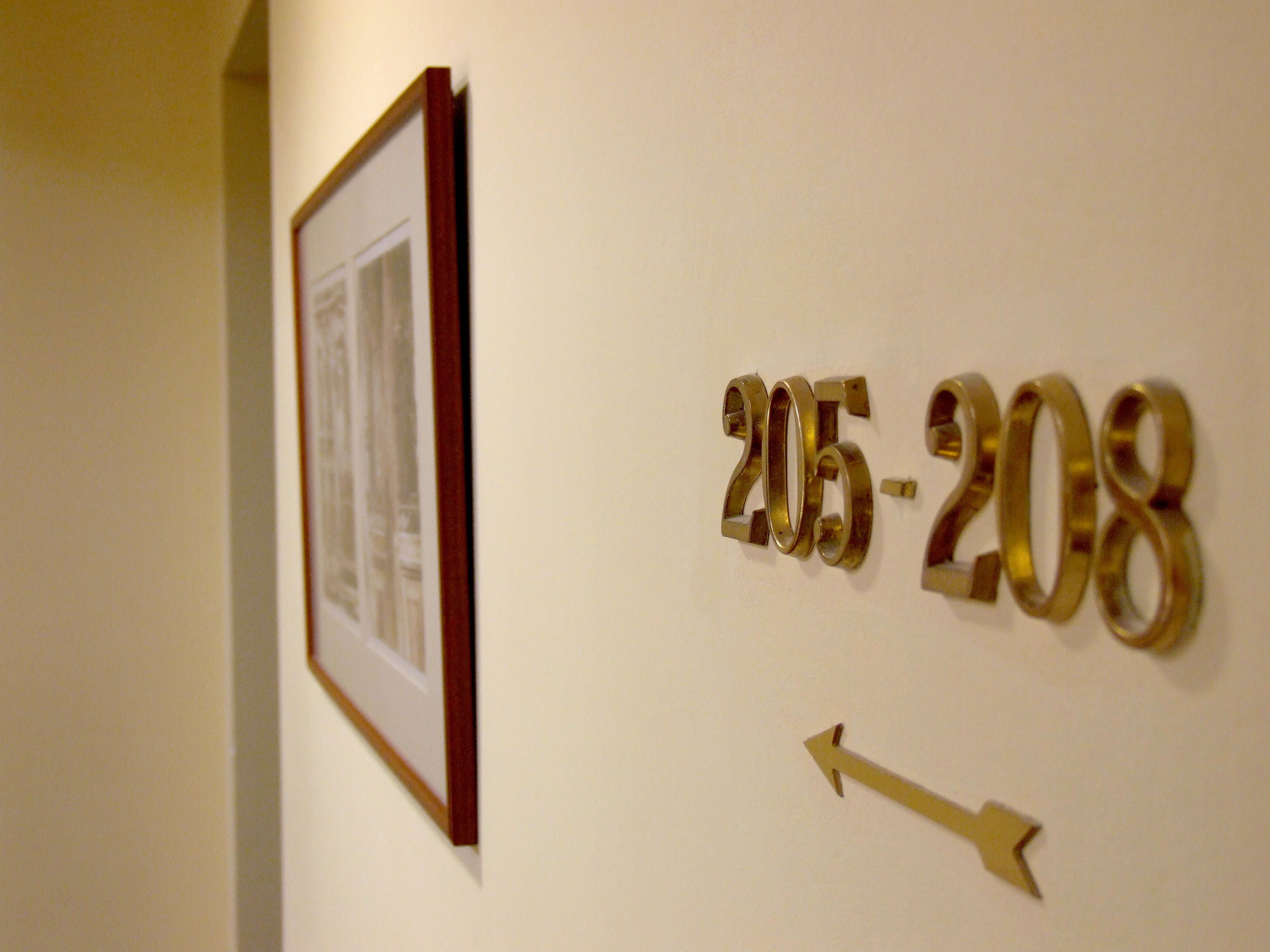 A wall with numbers '205-208' and a directional arrow.