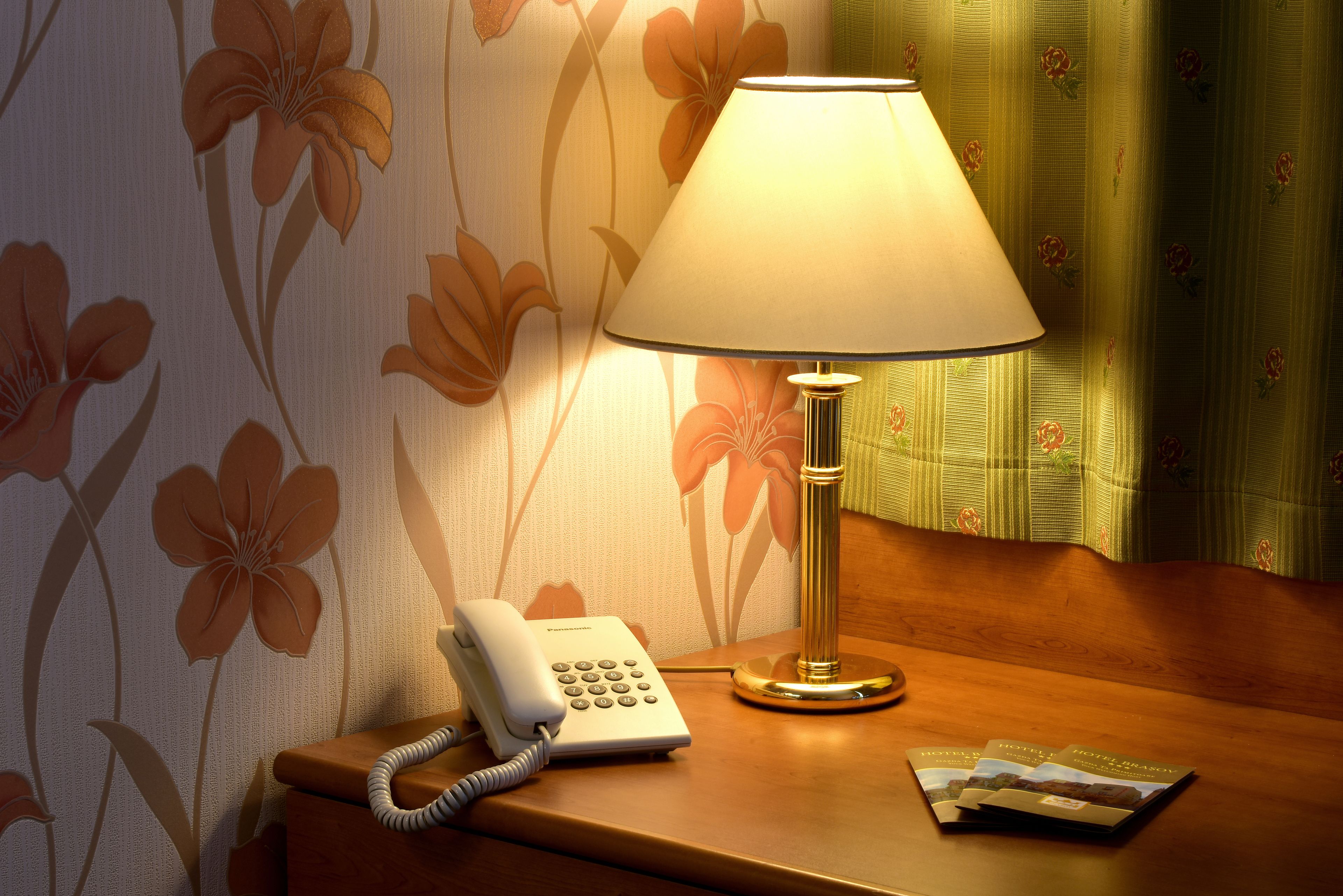 Une table de chevet avec une lampe, un téléphone et un magazine.